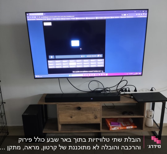 טלוויזיה גדולה על קיר עם מסך מחשב פתוח